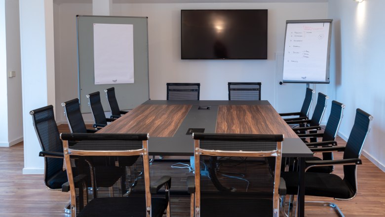 Szemin&aacute;riumi terem asztallal, sz&eacute;kekkel &eacute;s vet&iacute;tőv&aacute;szonnal