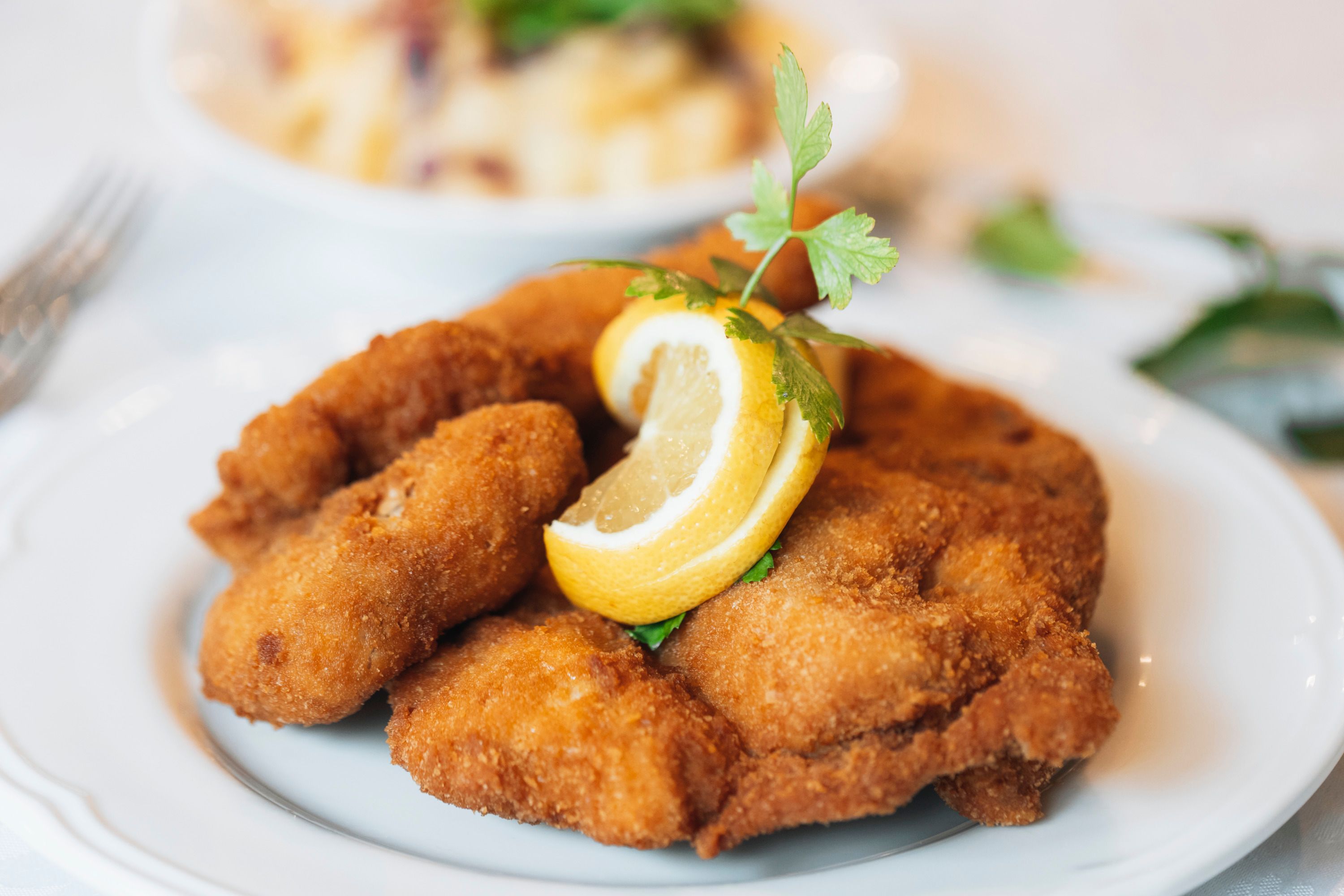 Sült csirke citromszelettel és petrezselyemmel a tányéron.