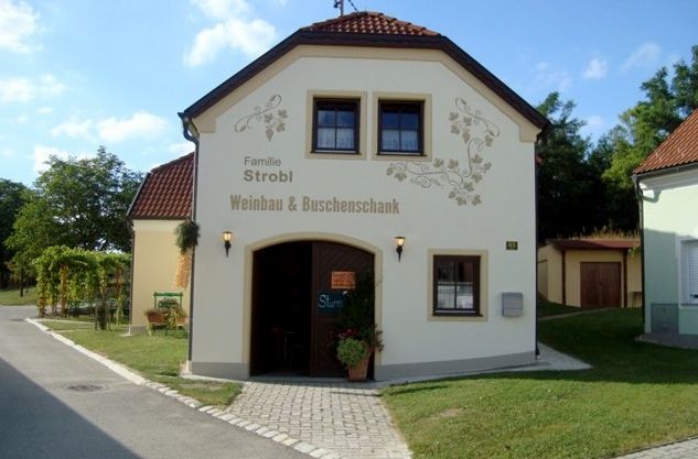 Egy kis épület a "Familie Strobl Weinbau & Hagyományos borozó" felirattal.