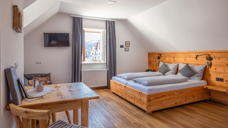 Lakásház Leopold an der Ybbs, © Niederösterreich Werbung / Maximilian Pawlikowsky Hangulatos hálószoba fabútorokkal és ferde mennyezettel.