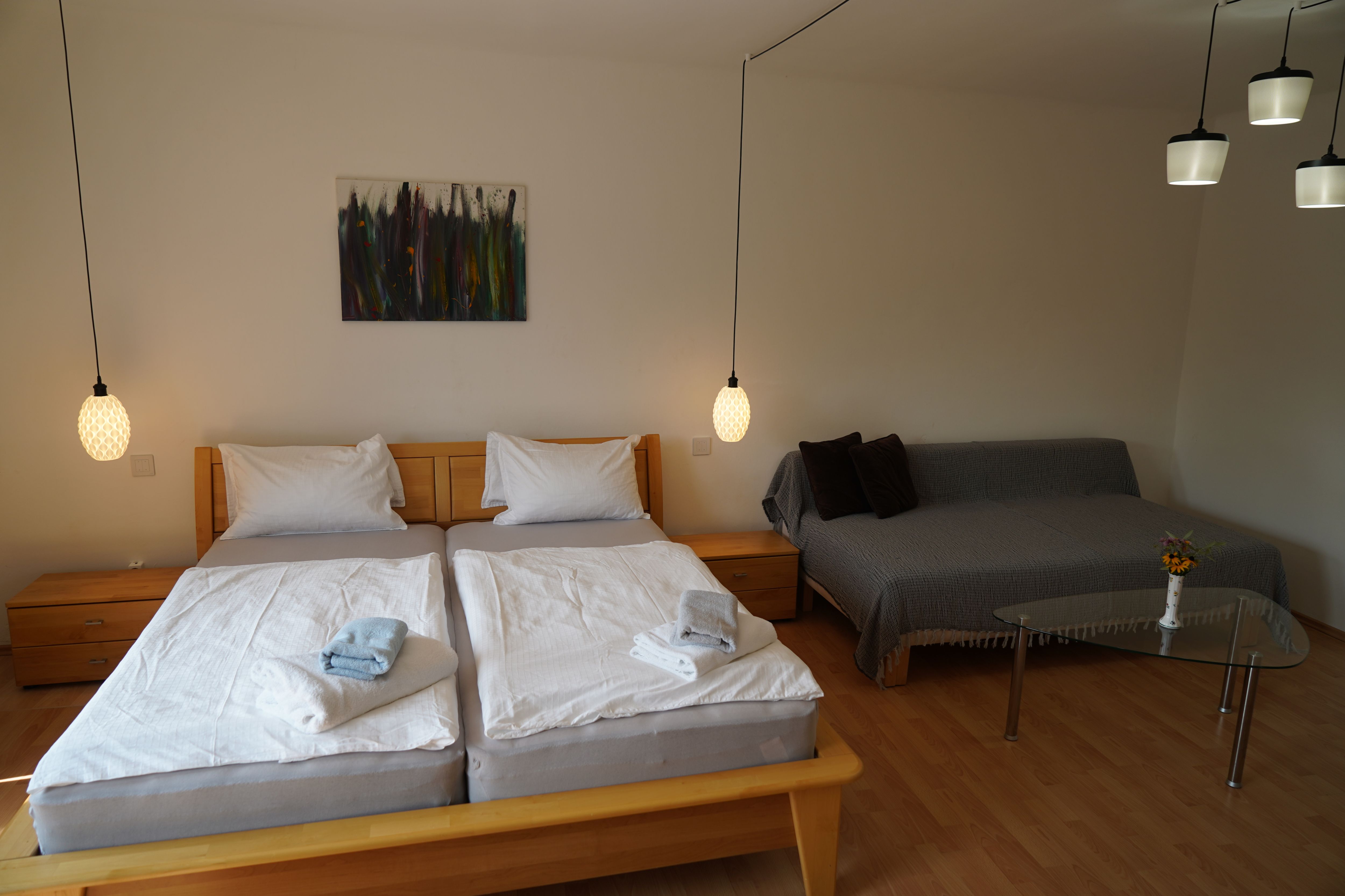 Hangulatos hálószoba franciaággyal, kanapéval és üvegasztallal.