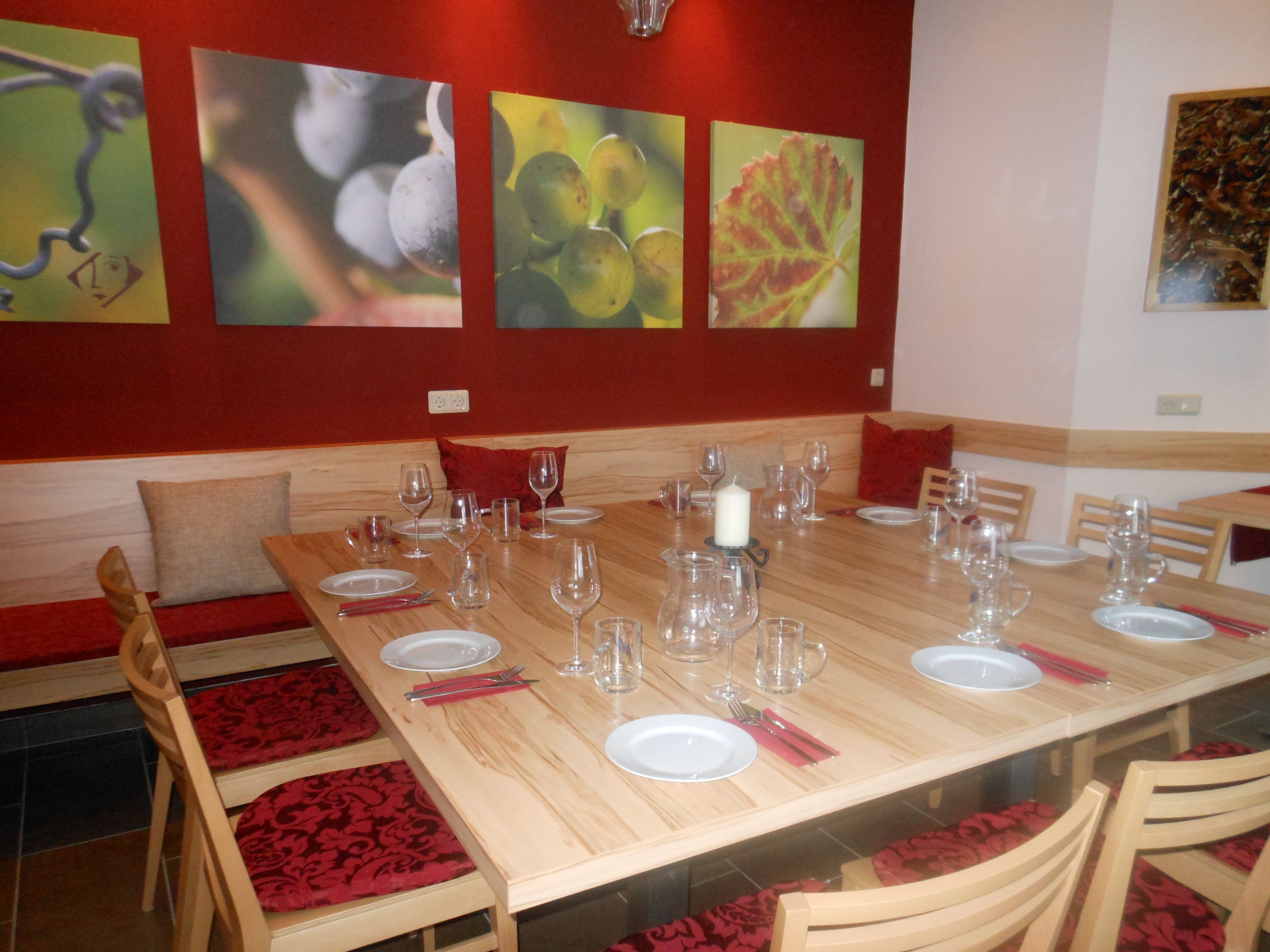 Kóstolóterem, fedett faasztallal, borospoharakkal és szőlőt ábrázoló falfestményekkel.