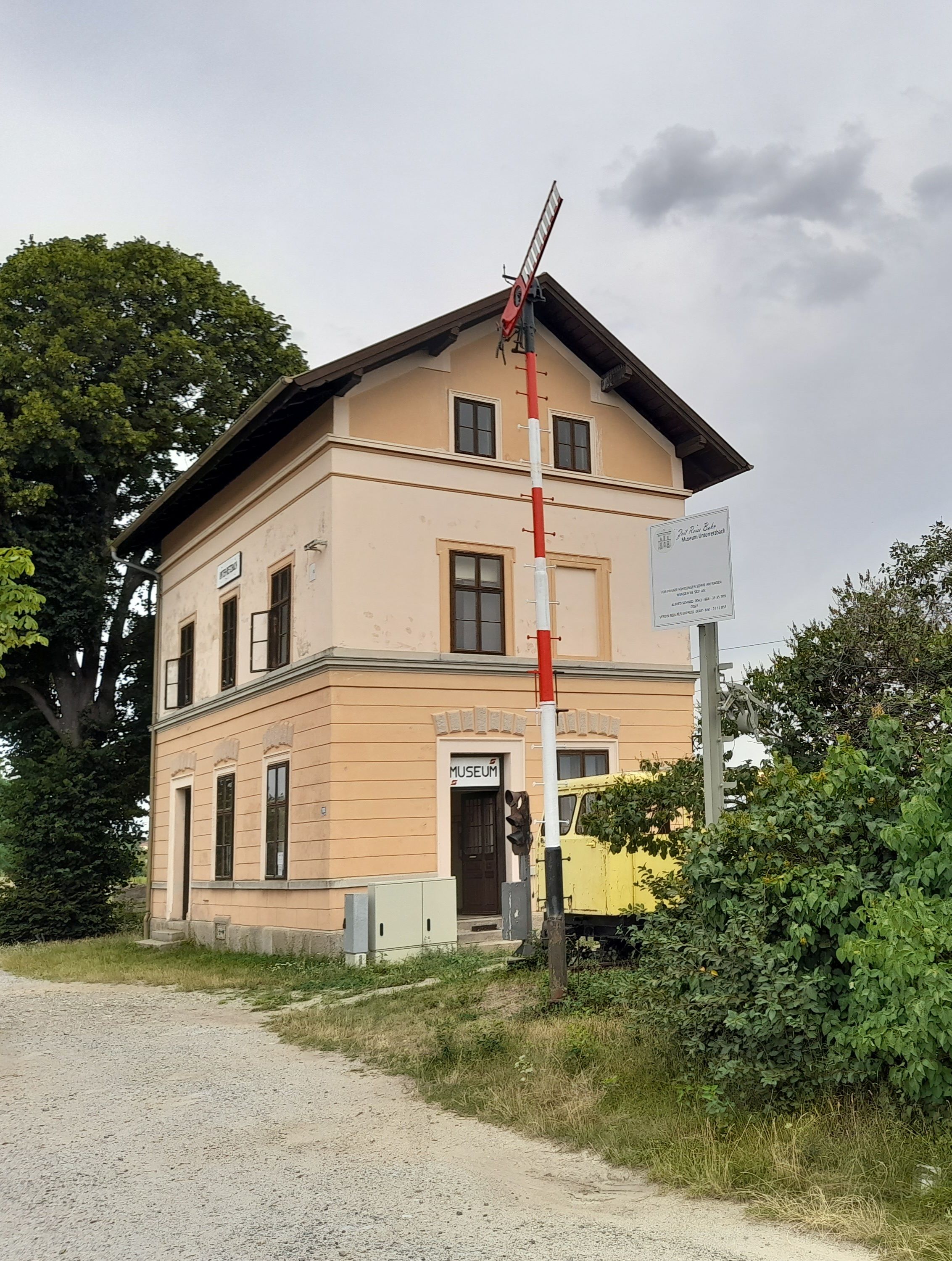 Régi vasútállomás épülete múzeumi jelzéssel és jelzővel Unter-Retzbachban.