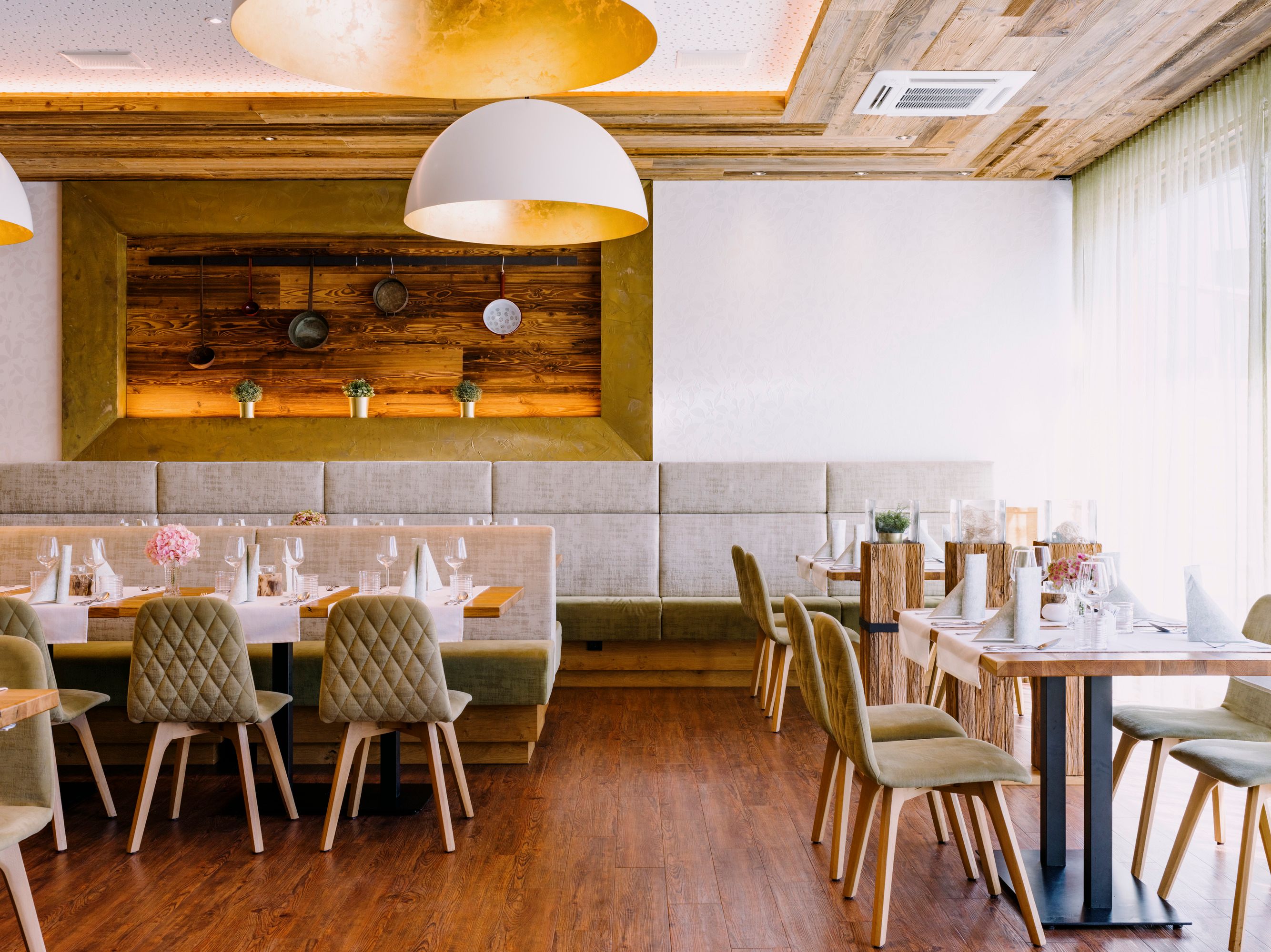 Modern étterem fa elemekkel és elegáns asztali dekorációval.