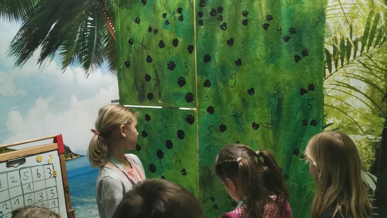 A gyerekek a teremben &aacute;llnak, &eacute;s felolvasnak egy rejtv&eacute;nyt.