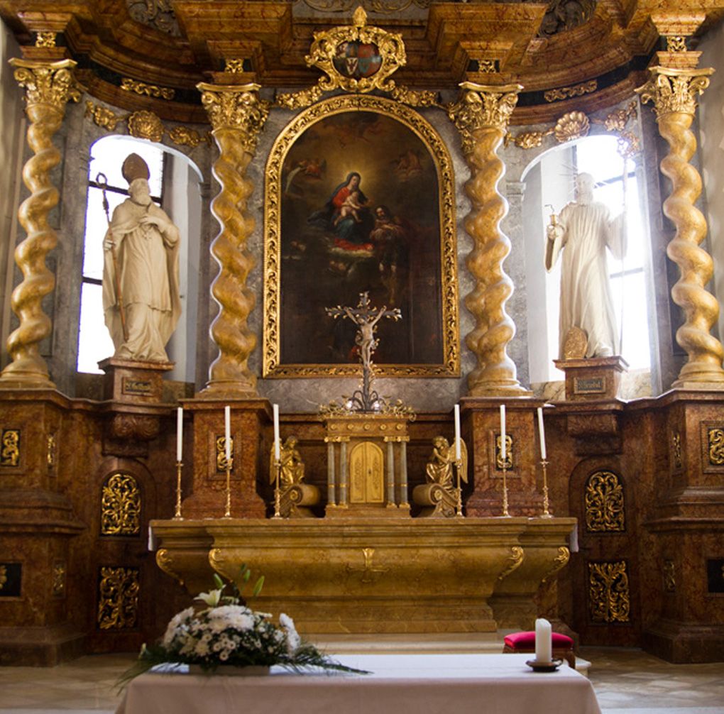 Oltár egy templomban, arany díszítésekkel és festményekkel.