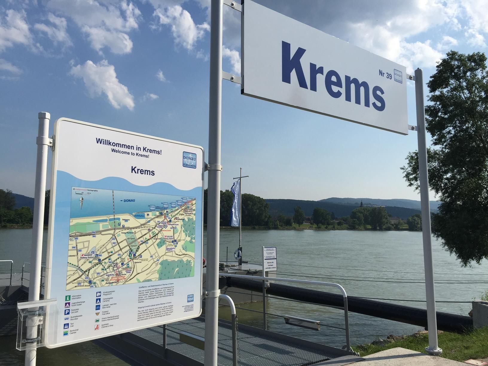 Kremsi móló üdvözlő táblával és Térképével, a háttérben a folyó.