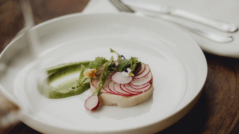 Sz&eacute;ns&uuml;lttel, retekkel &eacute;s wasabikr&eacute;mmel k&eacute;sz&uuml;lt &eacute;tel, ehető vir&aacute;gokkal d&iacute;sz&iacute;tve.