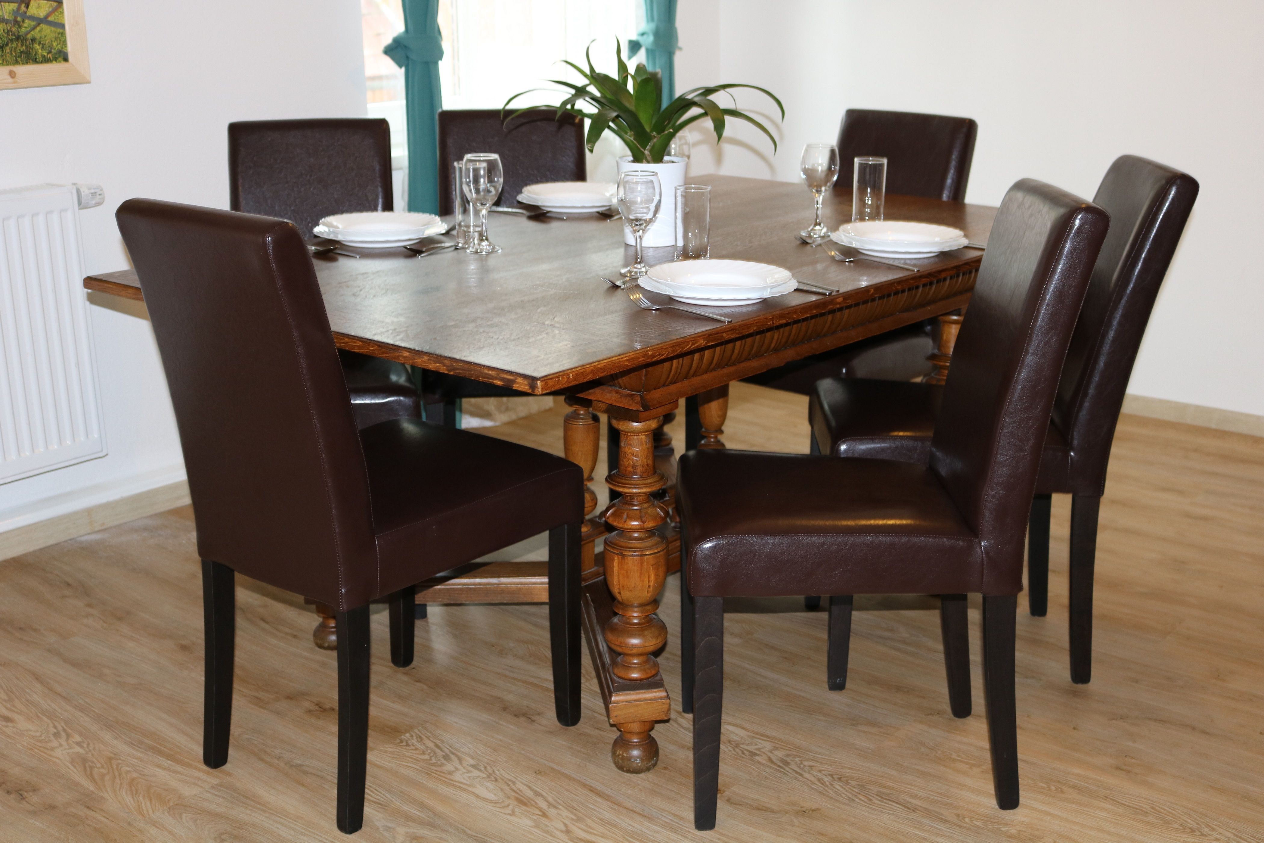 Étkezőhely, fa asztallal és hat barna székkel, hat személy számára.