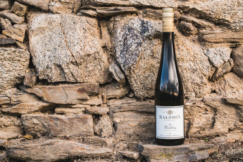 Borosüveg egy kőfal előtt.