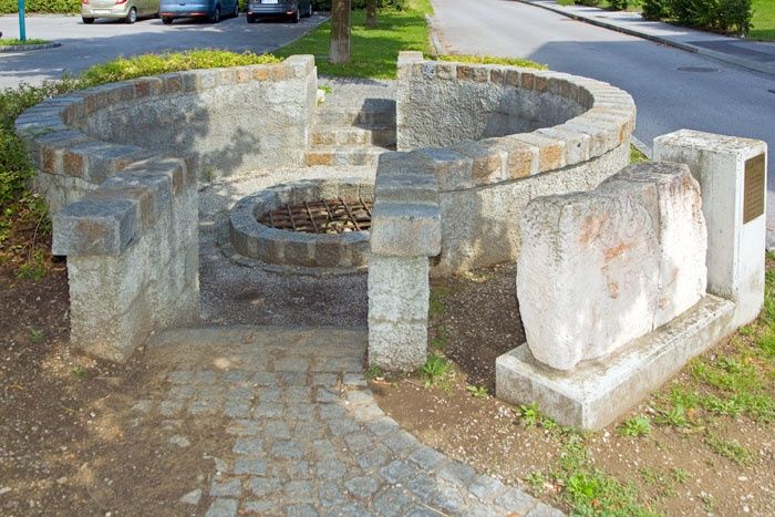 Római kori kút Traismauerben, kőszerkezetekkel és a nyílás fölötti ráccsal.