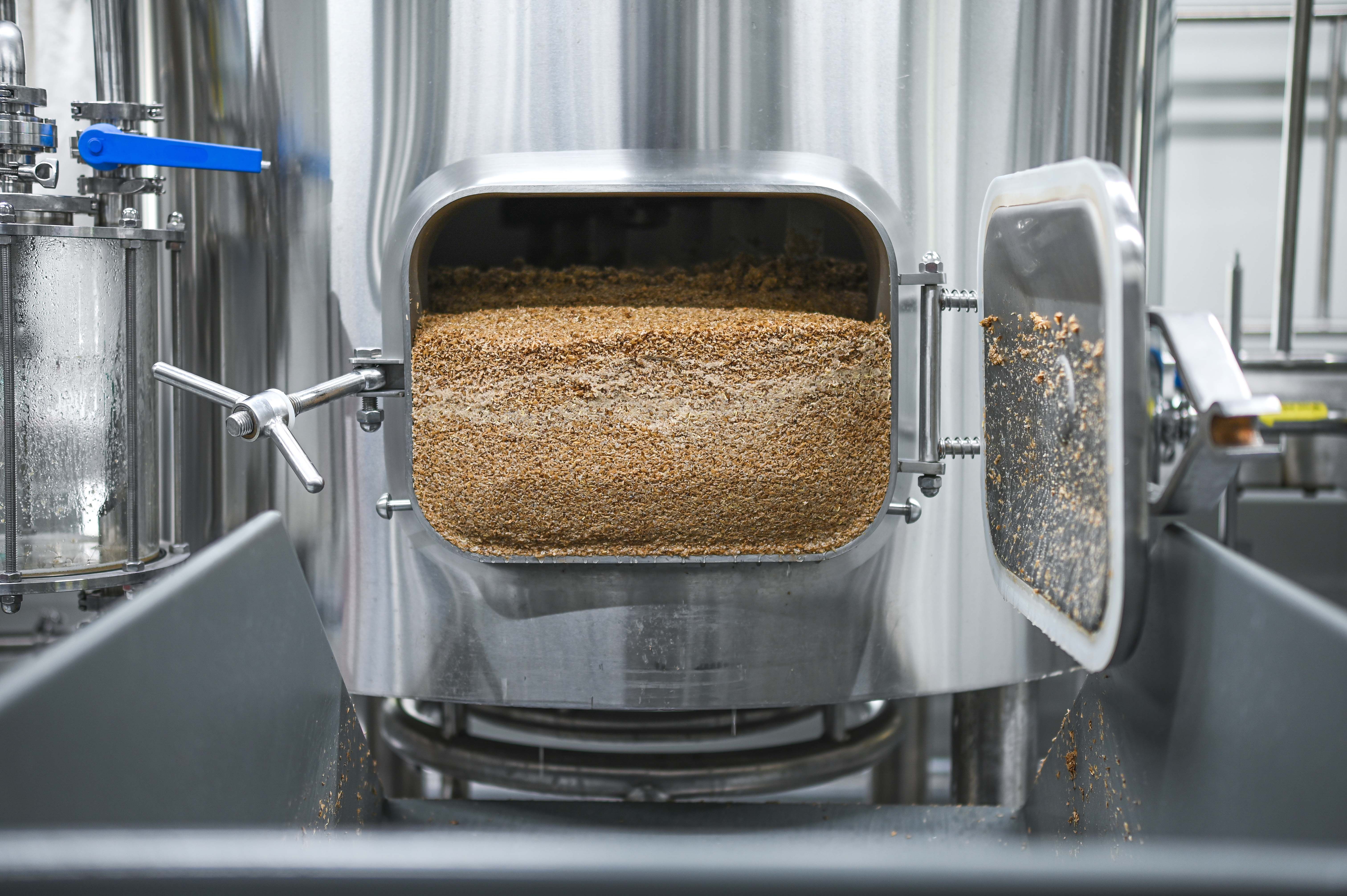 Megnyitott főzőüst maradék gabonával egy sörfőzdében.