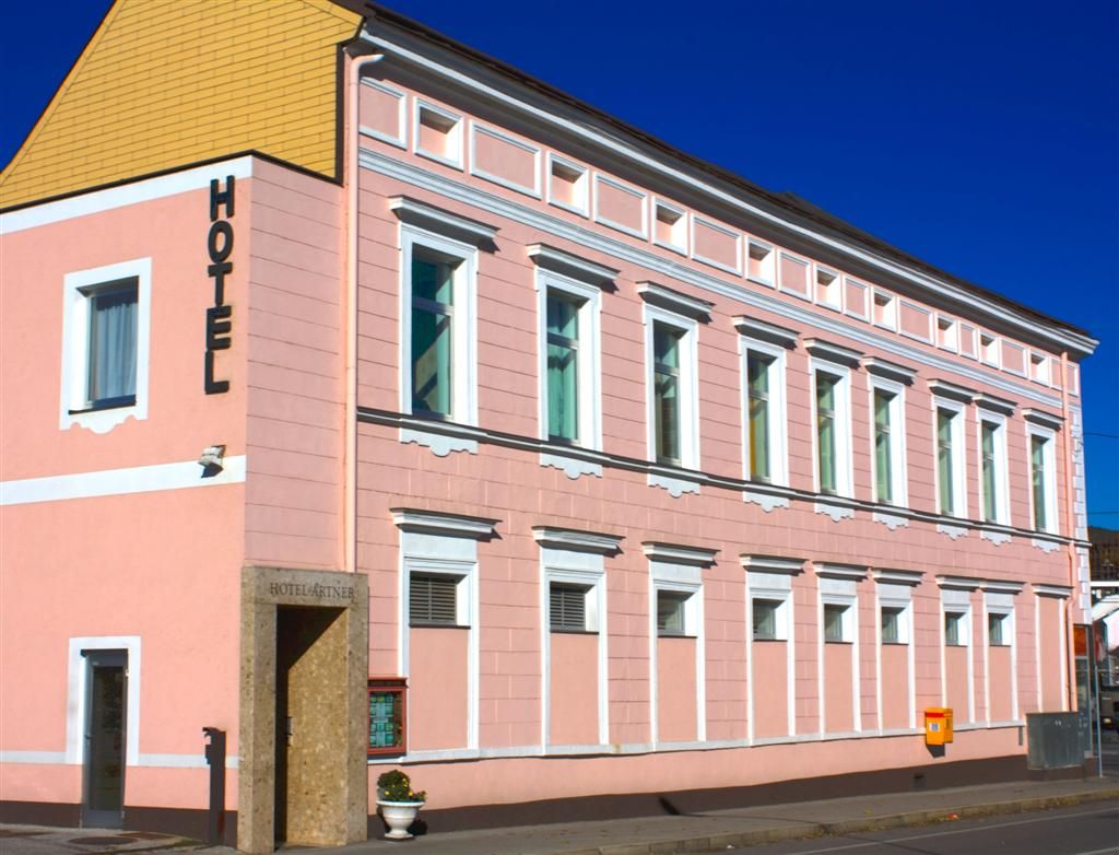 Egy rózsaszín épület, homlokzatán a "Hotel" felirattal.