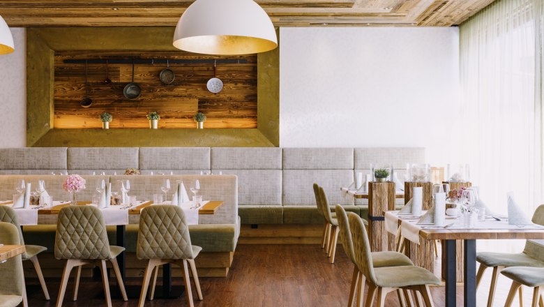 Modern étterem fa elemekkel és elegáns asztali dekorációval.