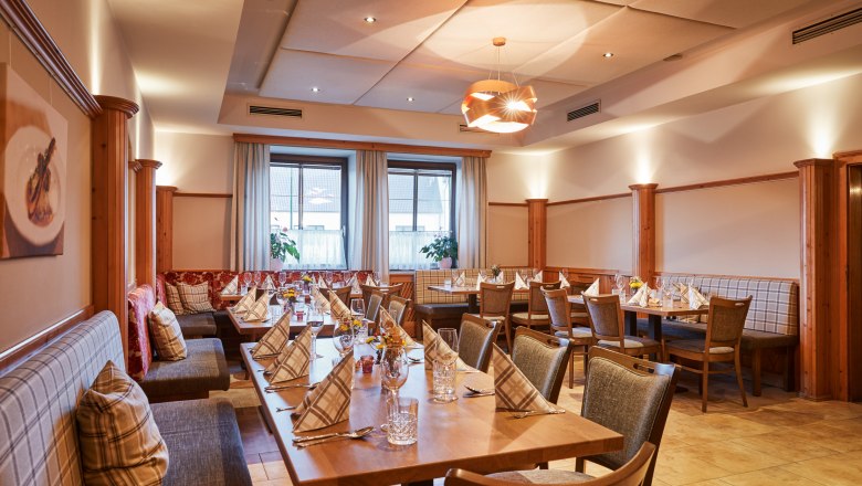 Hangulatos étkező terített asztalokkal és faburkolattal.