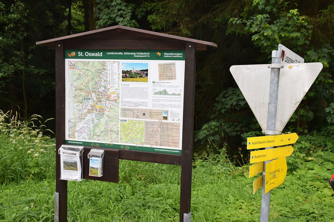 Túraútjelző tábla és információs tábla Szent Oswaldban, erdő és zöldövezetben.