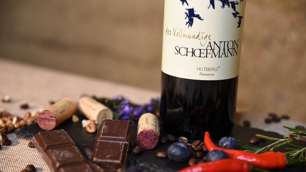 Borosüveg csokoládéval, parafával és fűszerekkel egy asztalon.