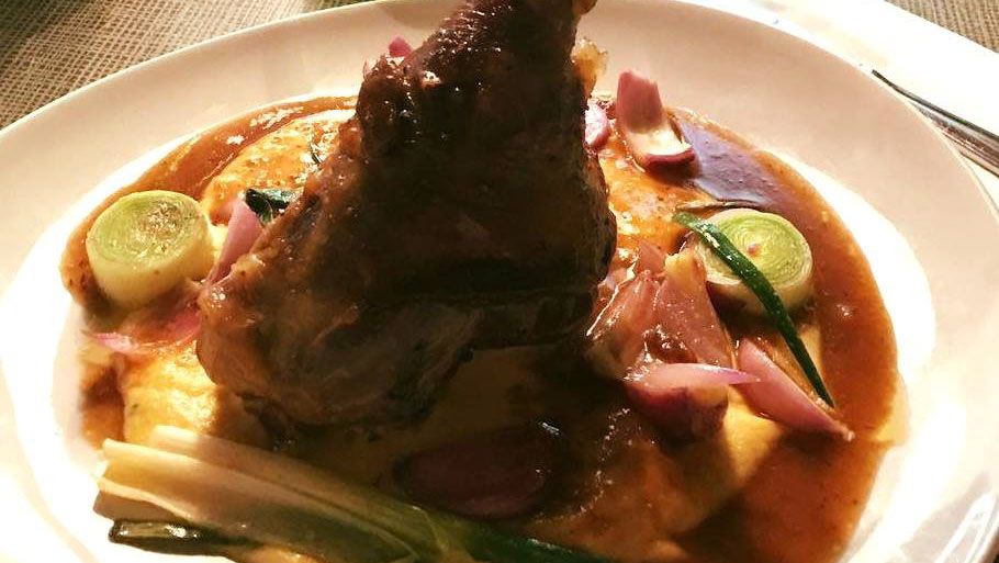 Egy tányér húsétel, amelyet burgonyapürével, barna mártással és zöldségekkel tálalnak.