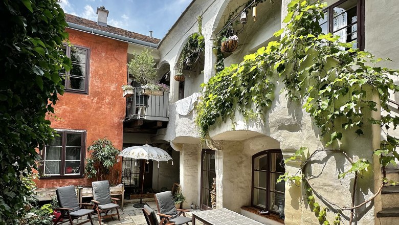 Hangulatos udvar n&ouml;v&eacute;nyekkel, fab&uacute;torokkal &eacute;s napernyővel.