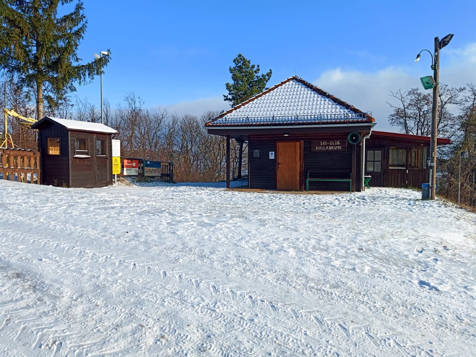 Hóval borított turistaház, a háttérben faház és fák.