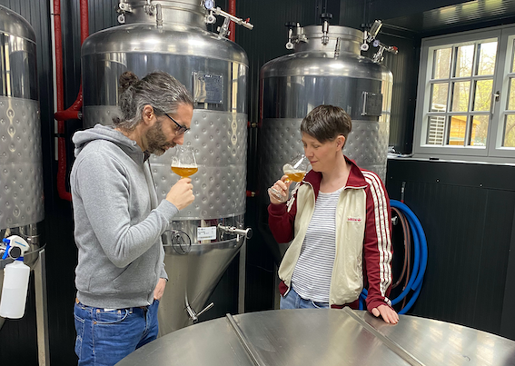 Egy modern kávézó belső nézete, fagerendákkal, bárpultokkal és asztalokkal.