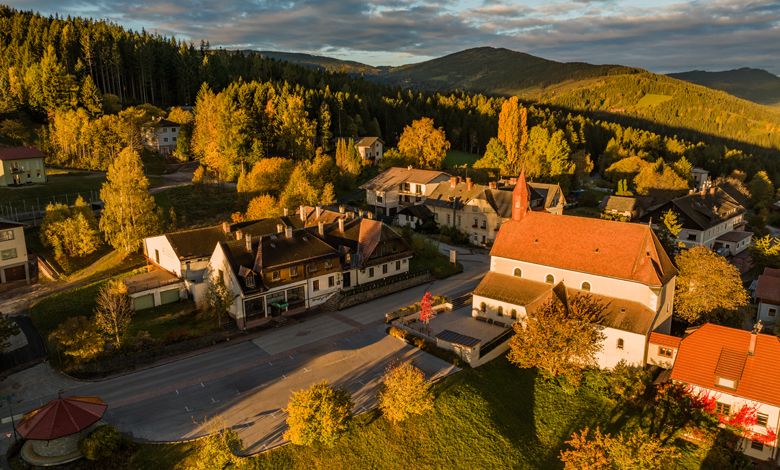 Légi felvétel a St. Corona am Wechselről, a templom és a környező épületek őszi tájban.