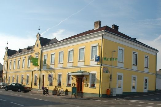 Sárga vendéglő egy utcasarkon, több ablakkal és bejárattal.