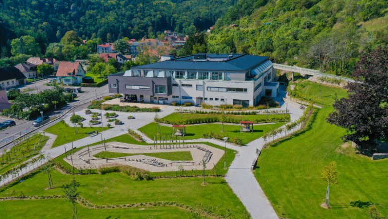 L&eacute;gi felv&eacute;tel egy modern &eacute;p&uuml;letről, kerttel, z&ouml;ld dombokkal k&ouml;r&uuml;lv&eacute;ve.