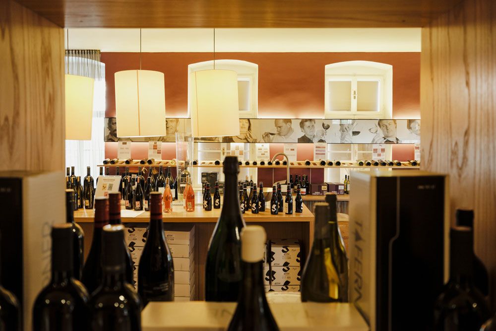 Egy borszaküzlet belső nézete borosüvegekkel és dekoratív lámpákkal.