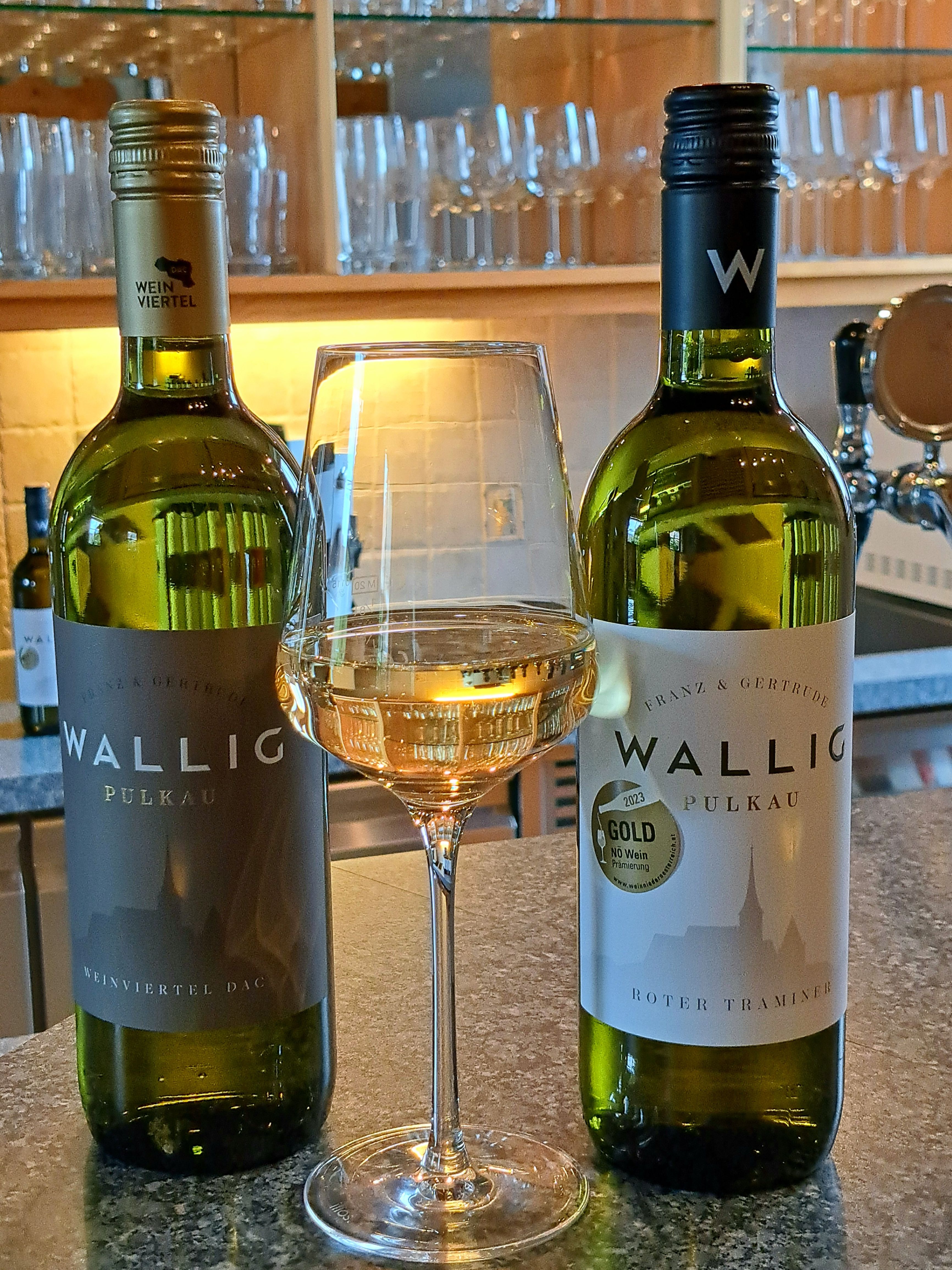 Két üveg bor és egy pohár fehérbor a pulton.