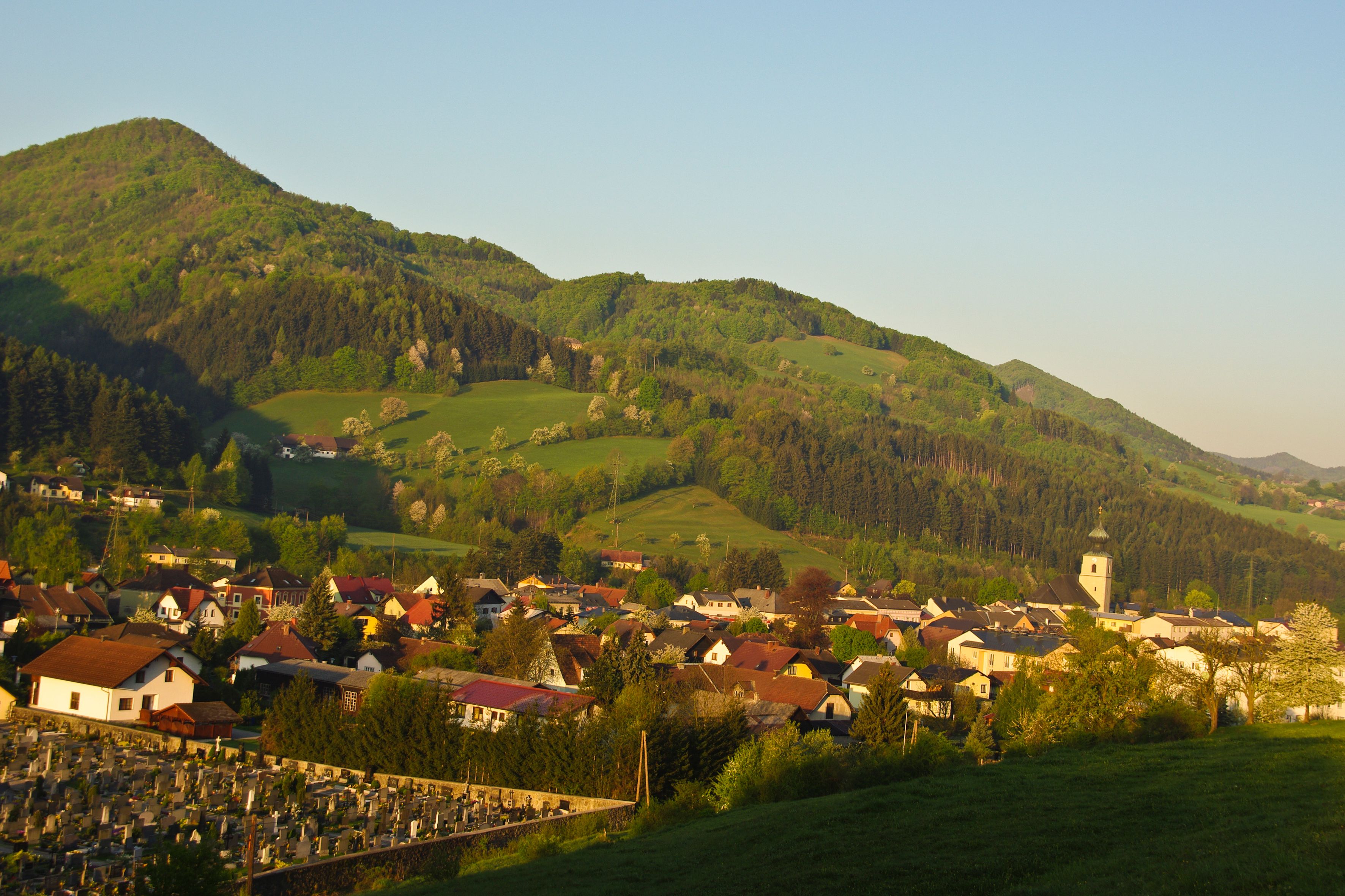 St. Veit an der Gölsen panorámája, háttérben a templom és a hegyek.