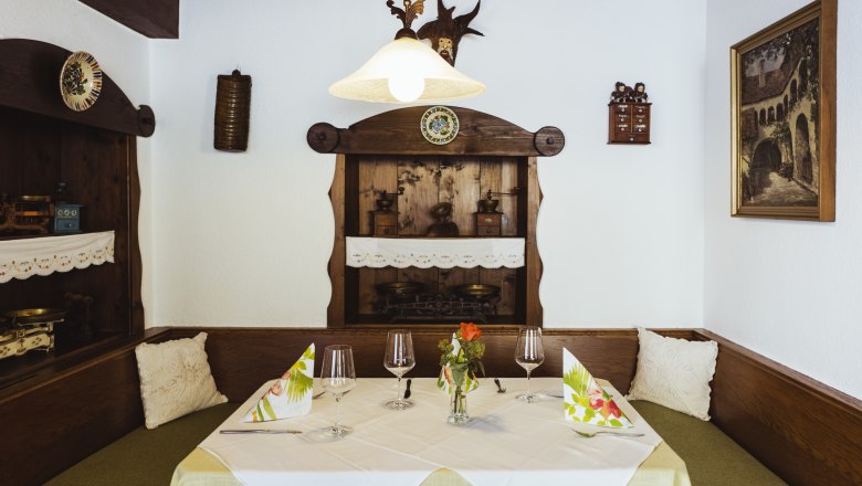 Hangulatos &uuml;lőhely egy &eacute;tteremben, fab&uacute;torokkal, dekorat&iacute;v r&eacute;szletekkel &eacute;s ter&iacute;t&eacute;kkel.