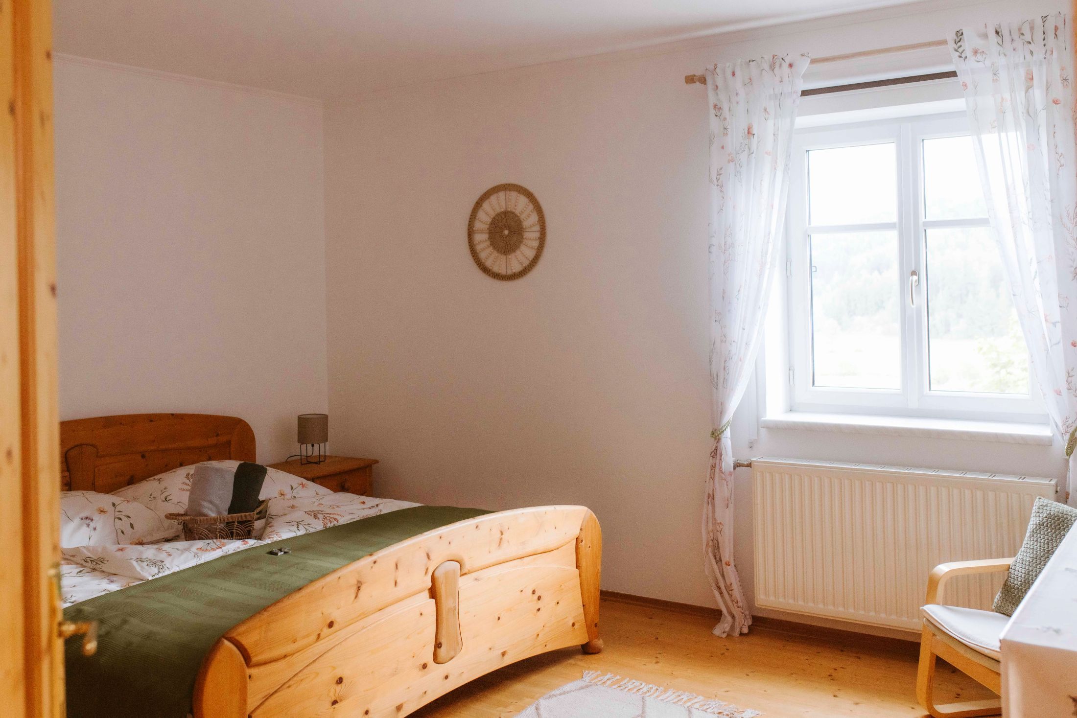 Hangulatos kétágyas szoba fabútorokkal és függönyös ablakkal.