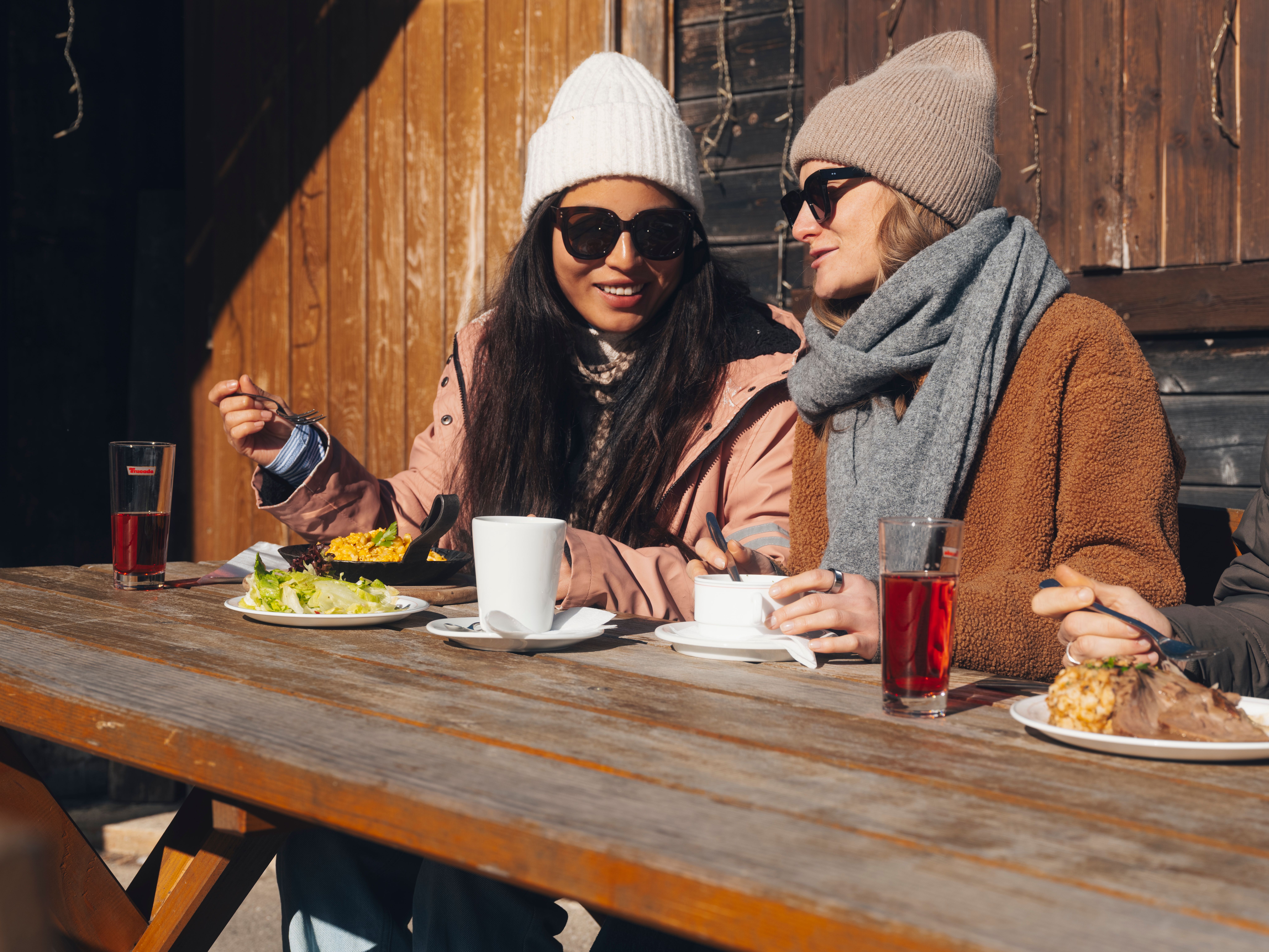 Két sífutó egy hóval borított pályán egy téli hegyvidéki tájban.