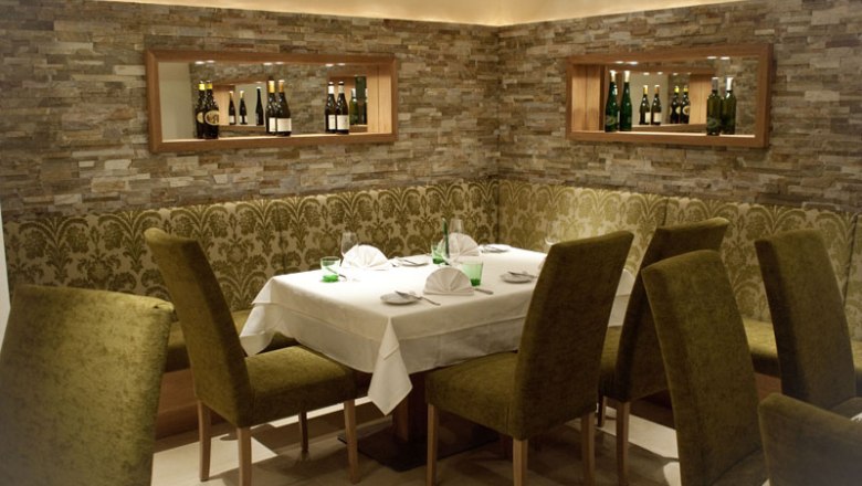 Eleg&aacute;ns &eacute;tterem ter&iacute;tett asztallal &eacute;s z&ouml;ld sz&eacute;kekkel.