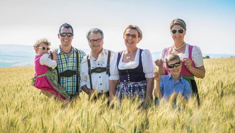 Familie Hopfeld in Tracht auf einem Feld.