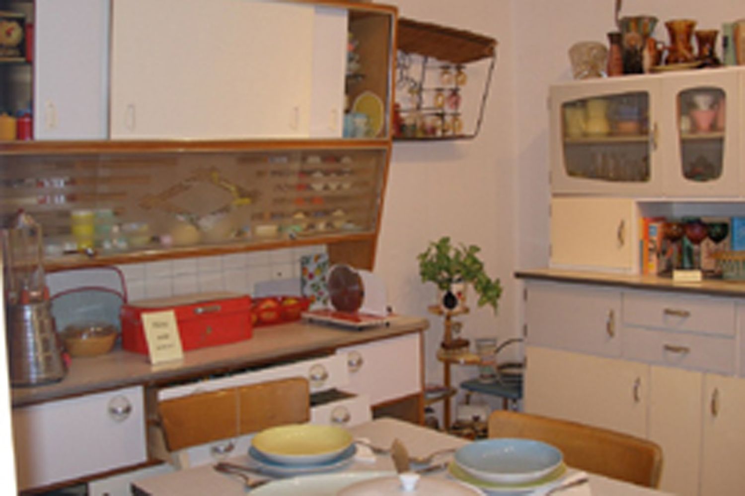 Egy konyhamúzeum belső nézete retro bútorokkal és edényekkel.
