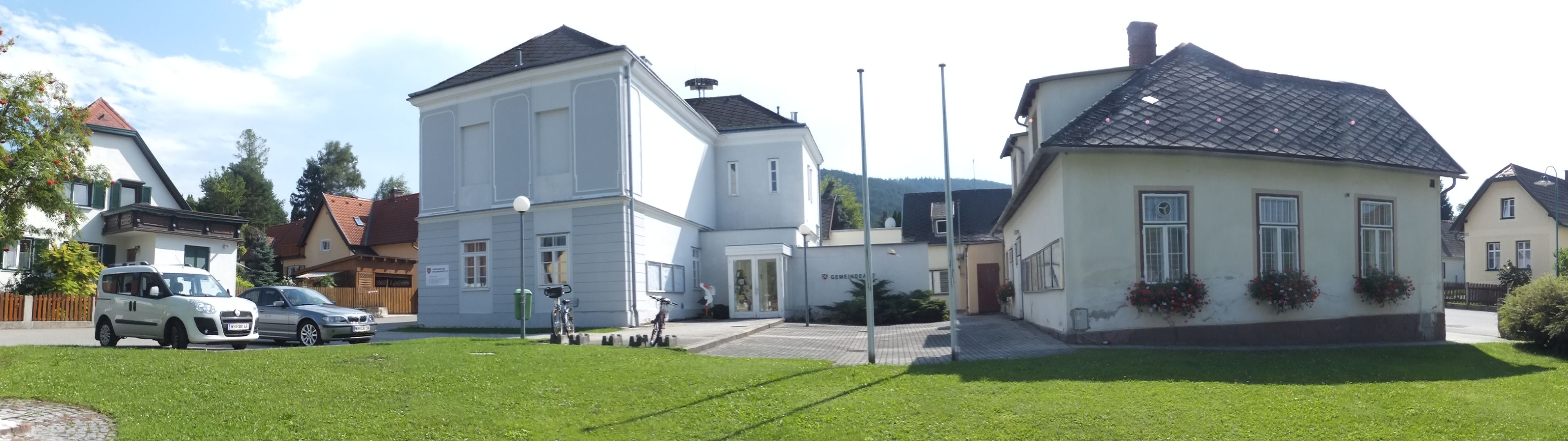 Panorámakép a waidmannsfeldi önkormányzati hivatalról a környező épületekkel és autókkal.