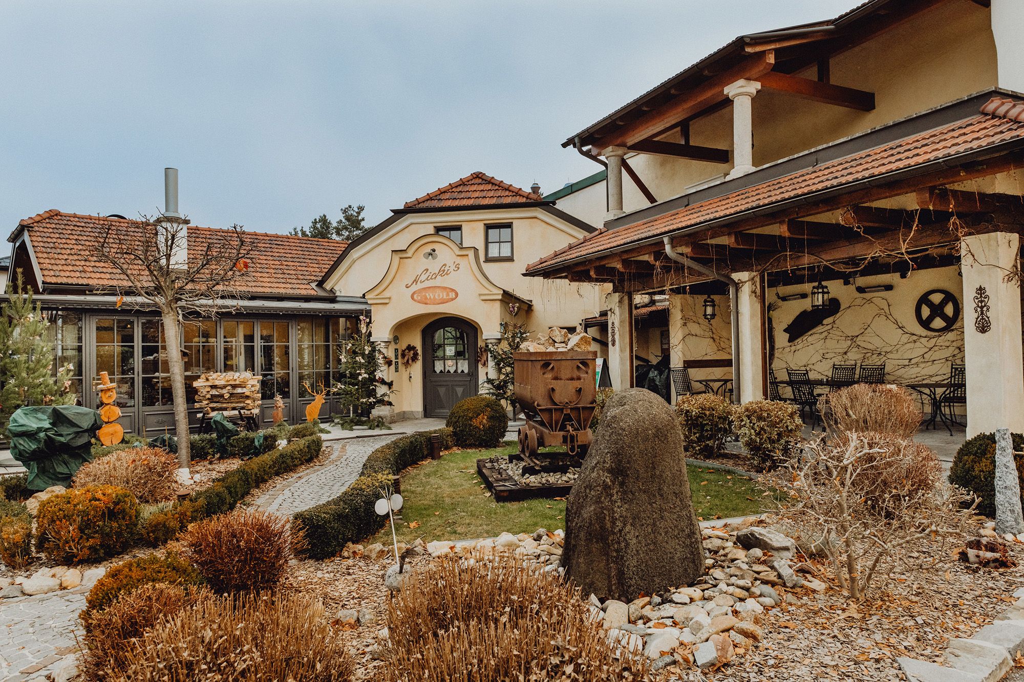 Egy hagyományos kocsma külső nézete kerttel és dekorációval.