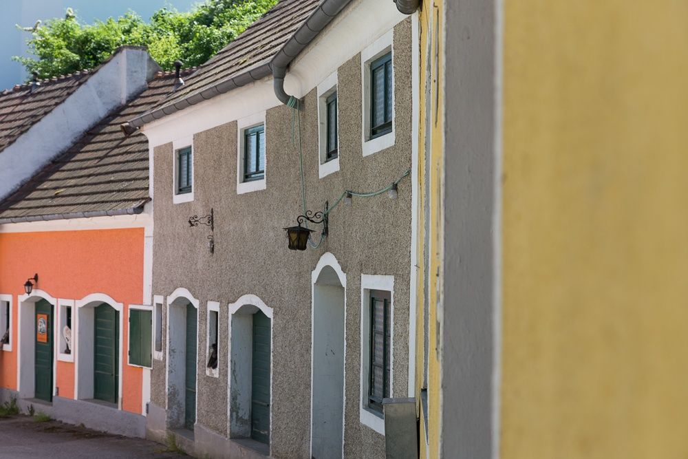 Színes házak egy Pincesoron, zöld ajtókkal és ablakokkal.