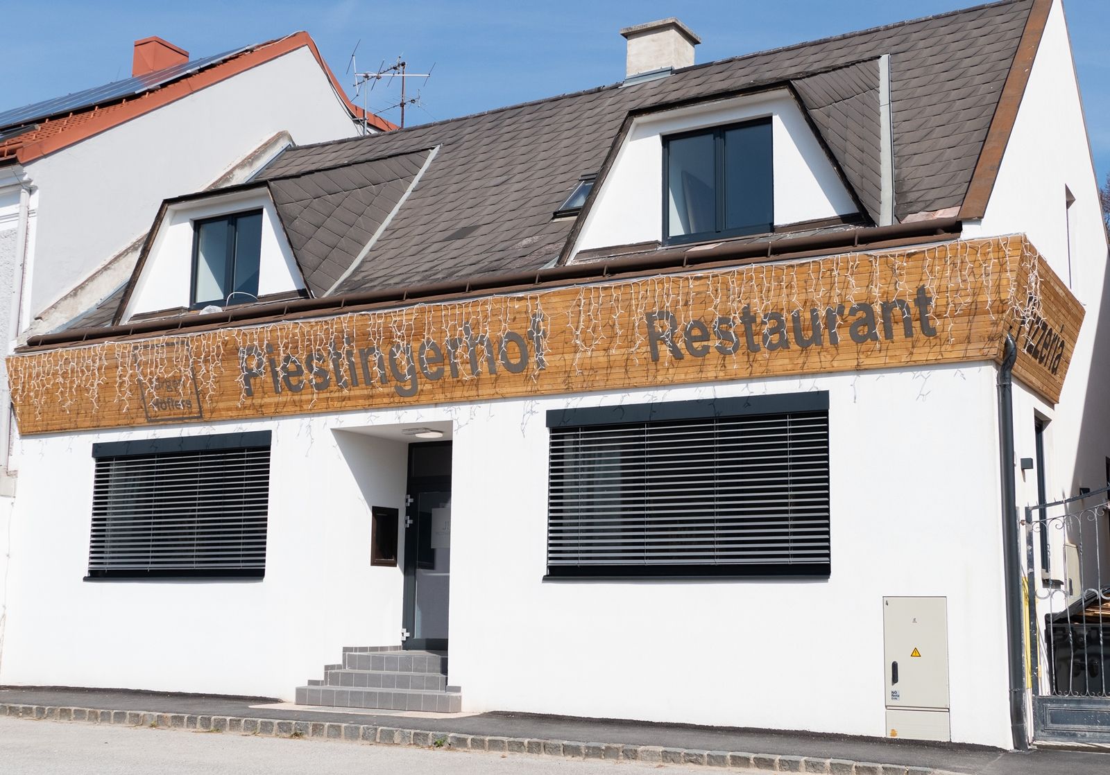 A Piestingerhof nevű étterem tündérfényekkel díszített homlokzata.