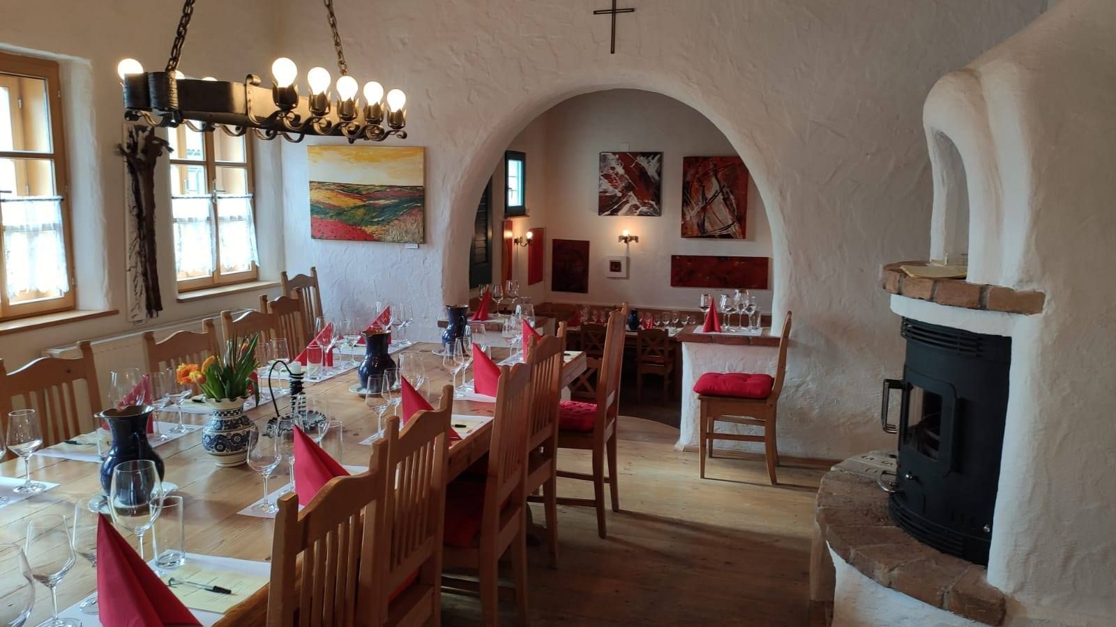 Hangulatos szoba terített asztallal, borospoharakkal és kandallóval.