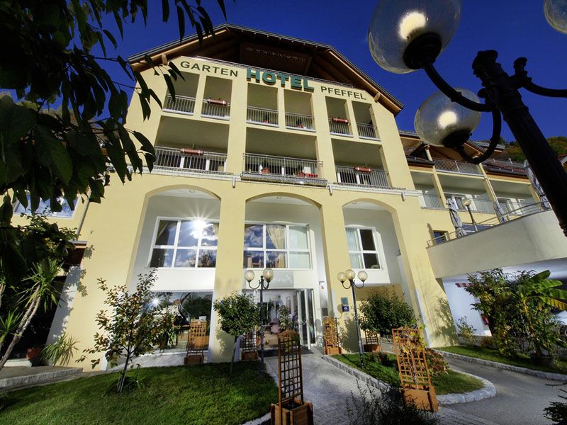 A Gartenhotel Pfeffel külső nézete sárga homlokzattal és erkélyekkel.
