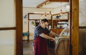 Egy f&eacute;rfi egy hangulatos nappaliban egy zeneg&eacute;pet kezel.