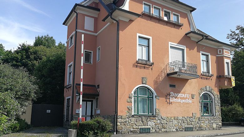 A "Tanzcafé Whiskymühle" feliratú kétszintes épület.
