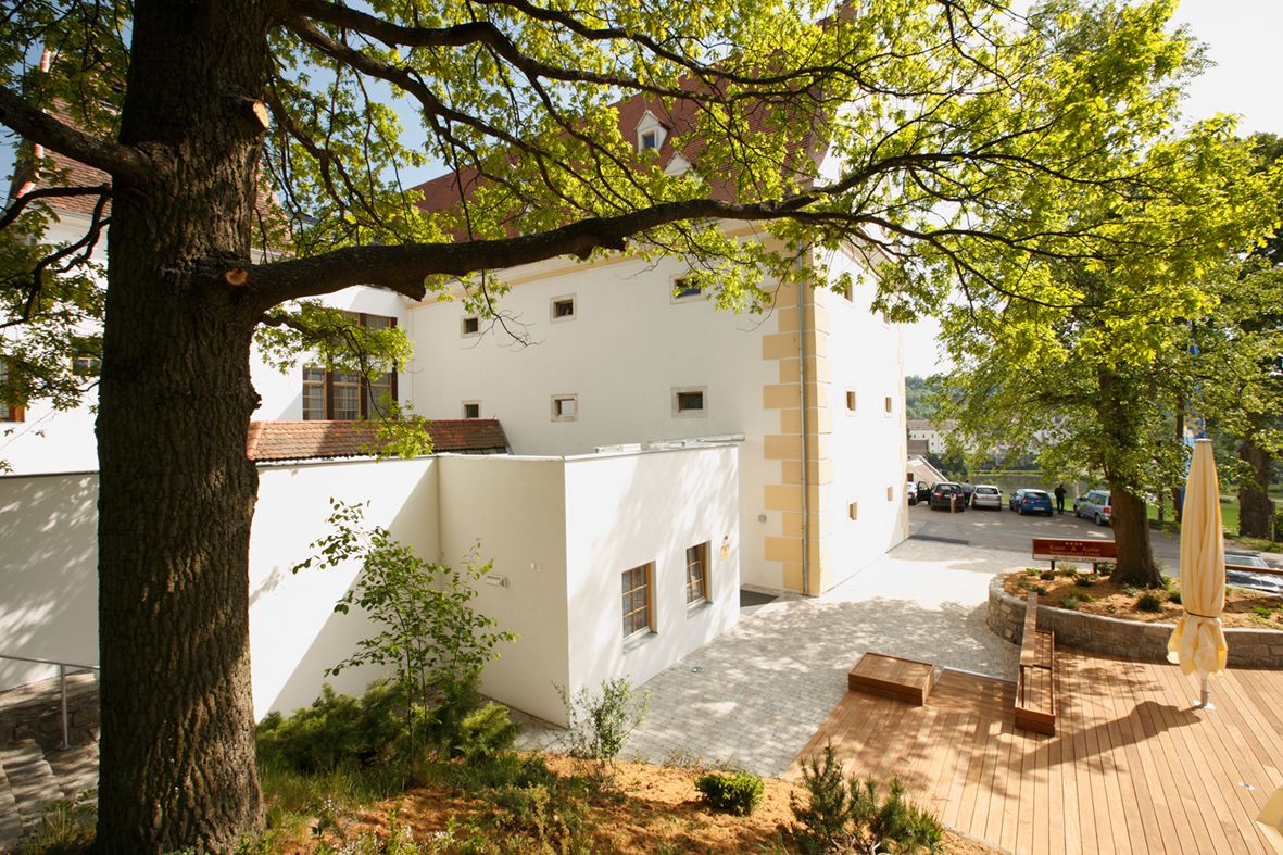 A Schüttkasten Geras külső nézete fákkal és terasszal.