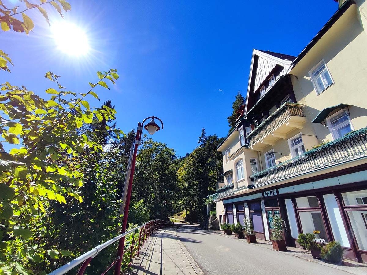 Napos nap egy erkélyes villa előtt, fákkal és fákkal.