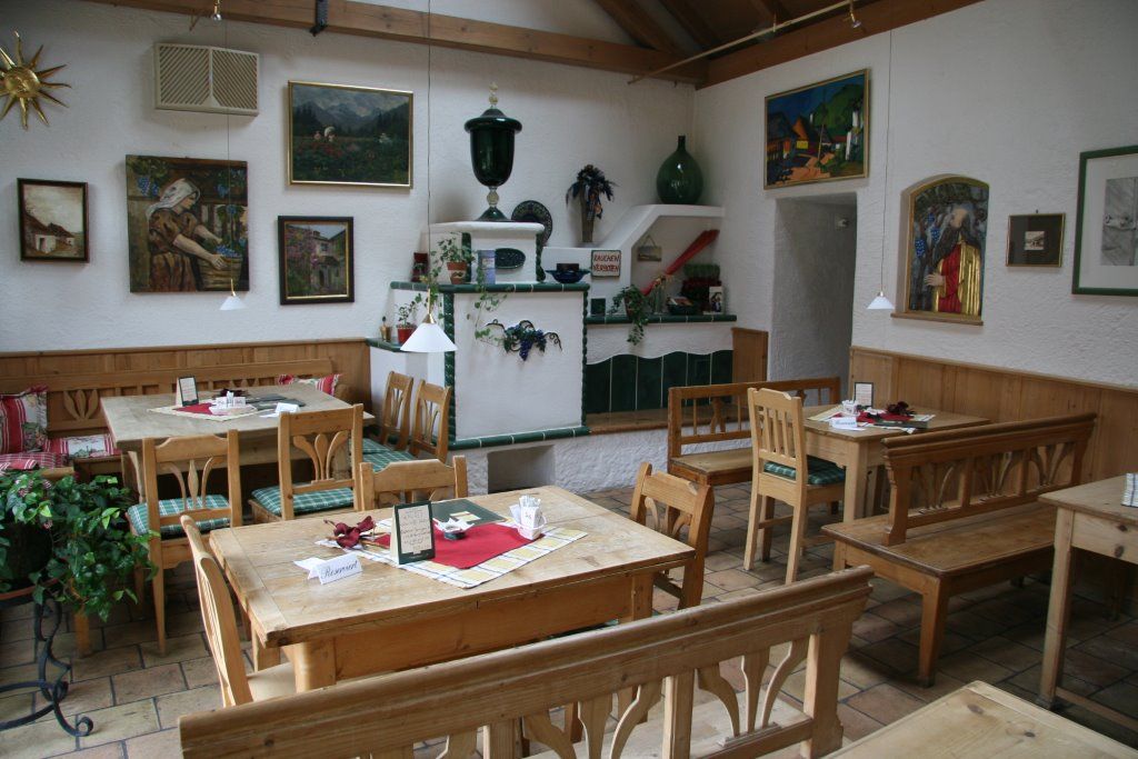 Hangulatos étkező, fából készült bútorokkal és dekoratív festményekkel a falakon.