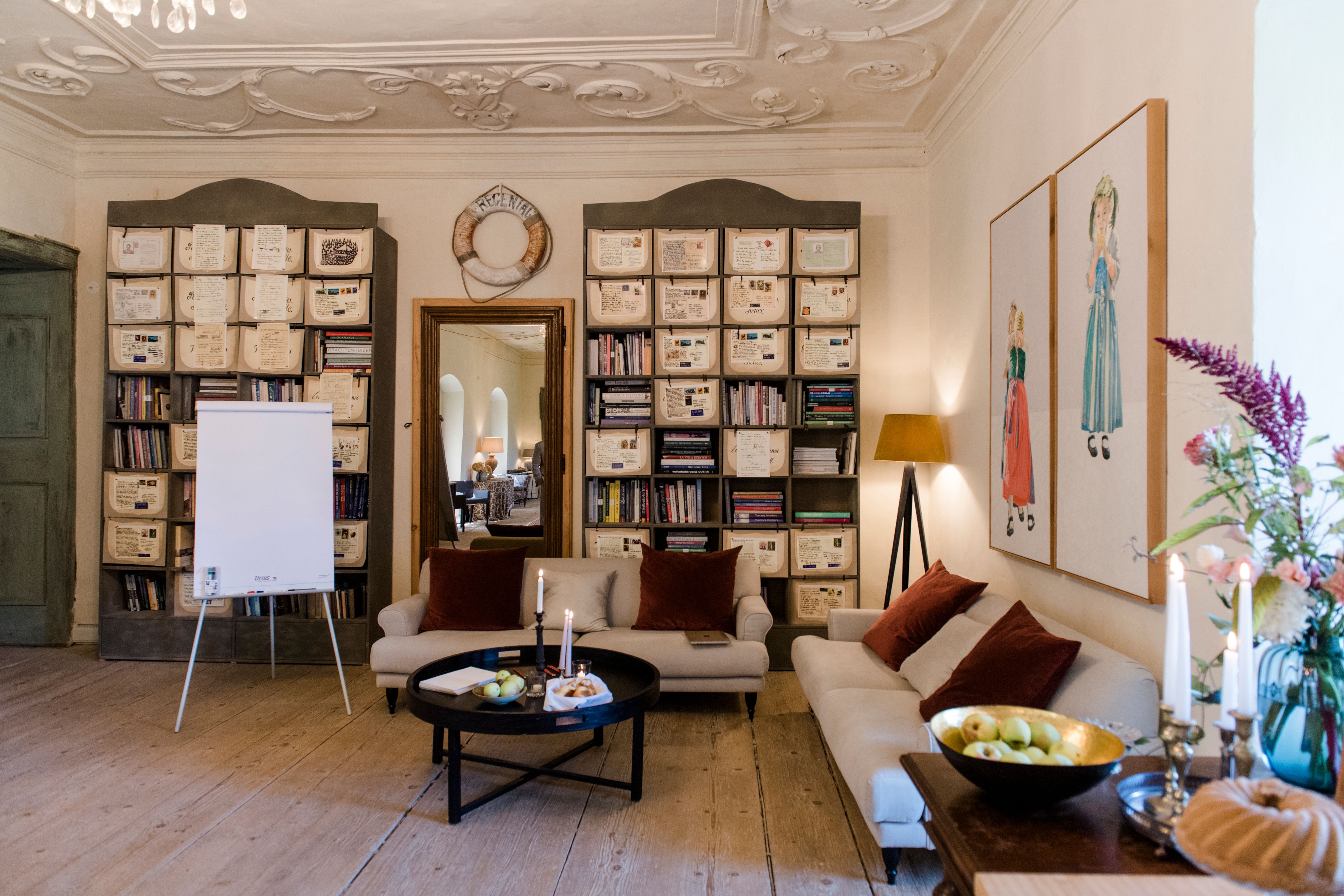 Hangulatos szoba kanapékkal, könyvespolcokkal és dekorációkkal.