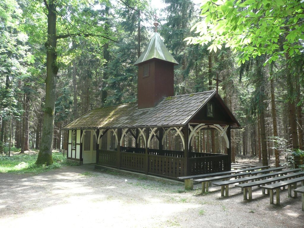 Egy kis kápolna az erdőben, kívül fapadokkal.